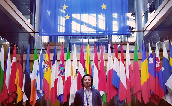 Víctor Hugo Ramírez García standing in front of European flags